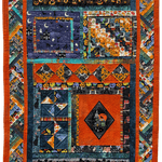 Colorful quilt with geometric patterns and vibrant colors in halloween-themed fabric.