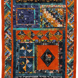 Colorful quilt with geometric patterns and vibrant colors in halloween-themed fabric.